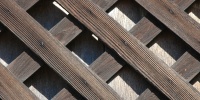 slats fence angled diamonds pattern shadow weathered architectural wood dark brown